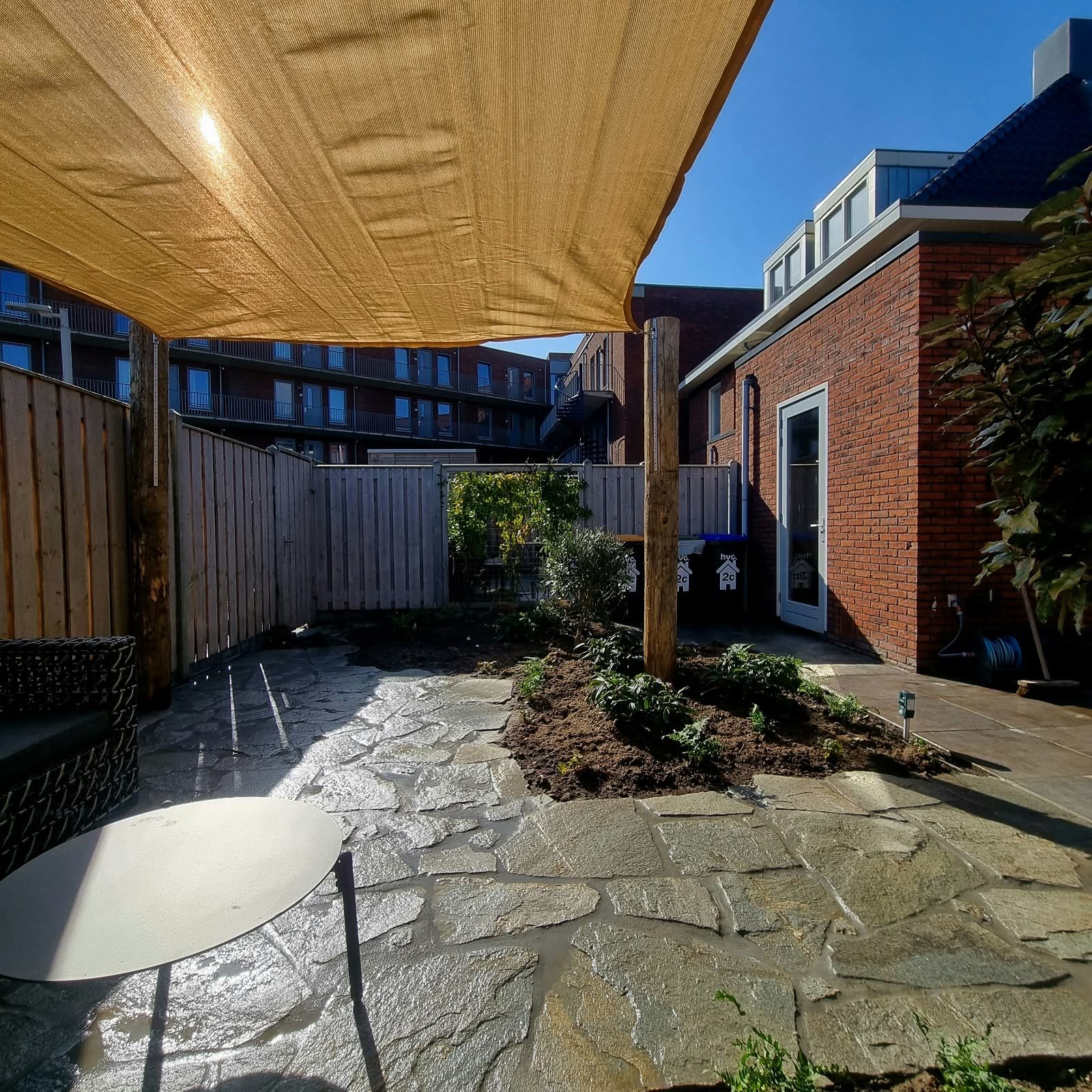 Schaduwdoek boven terras van flagstones
