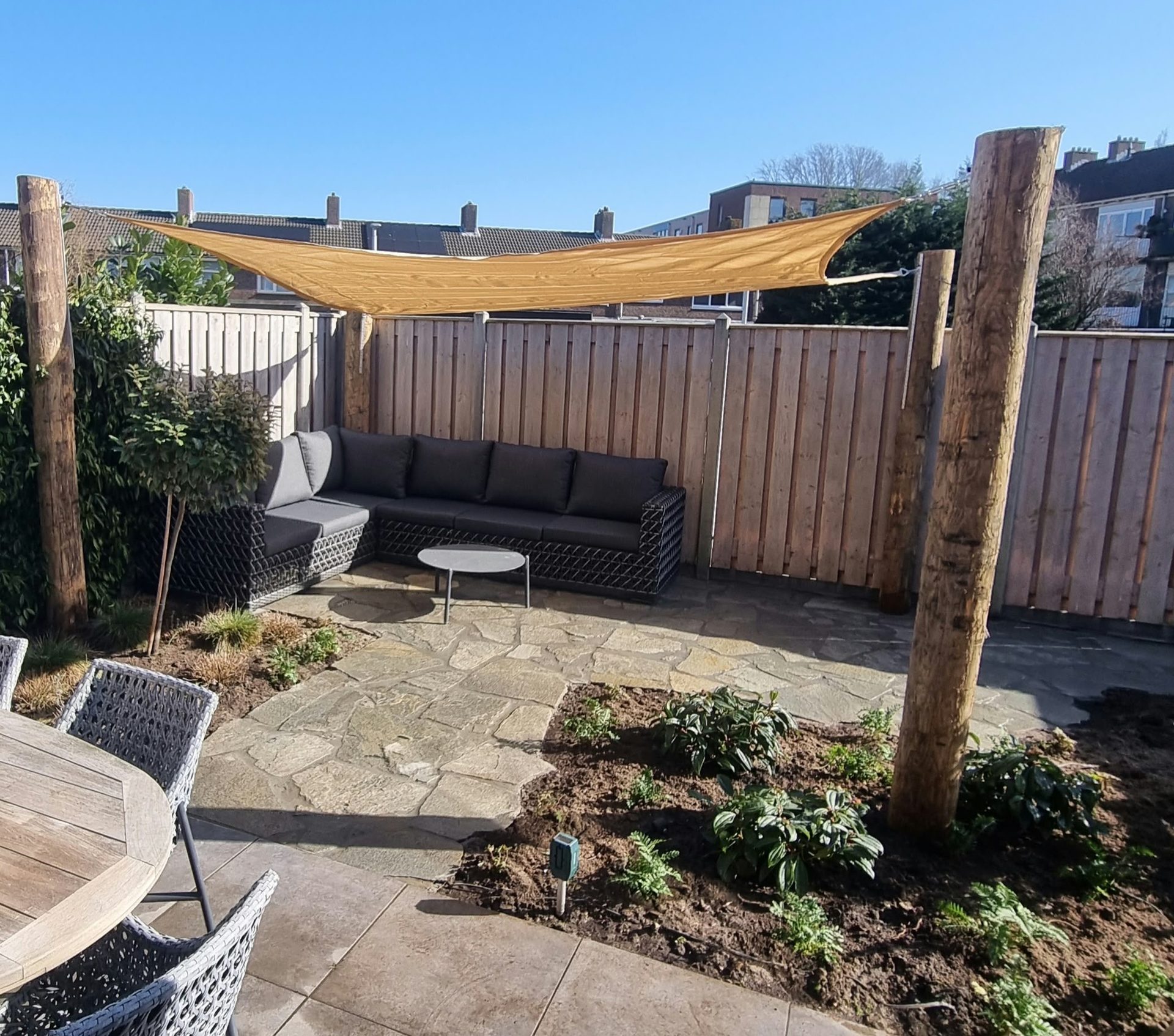 Schaduwdoek in tuin gespannen aan sloophouten palen