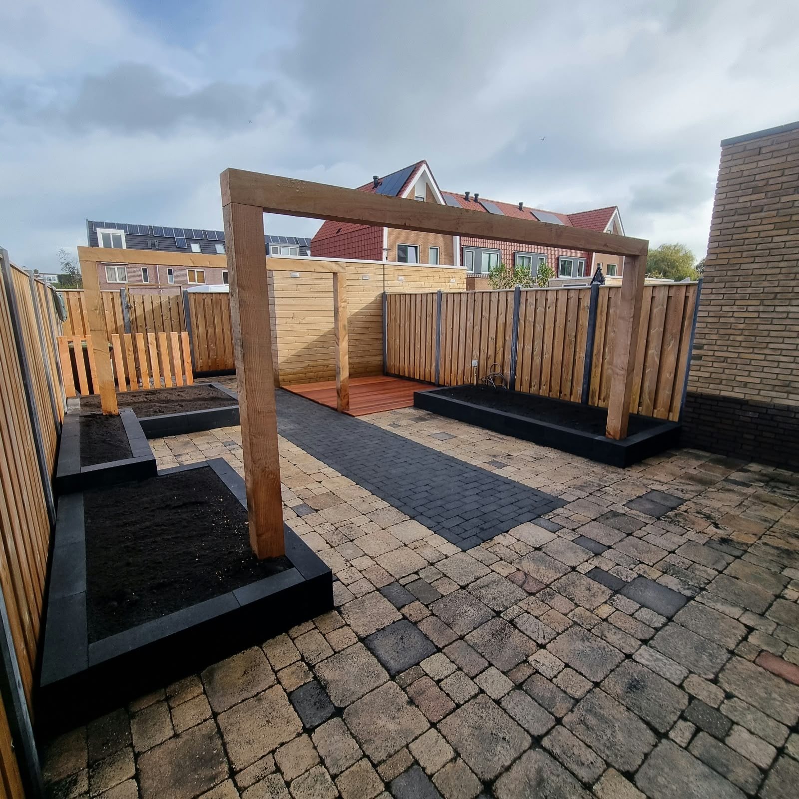 Aangelegde tuin met douglas portaal en sierbestrating