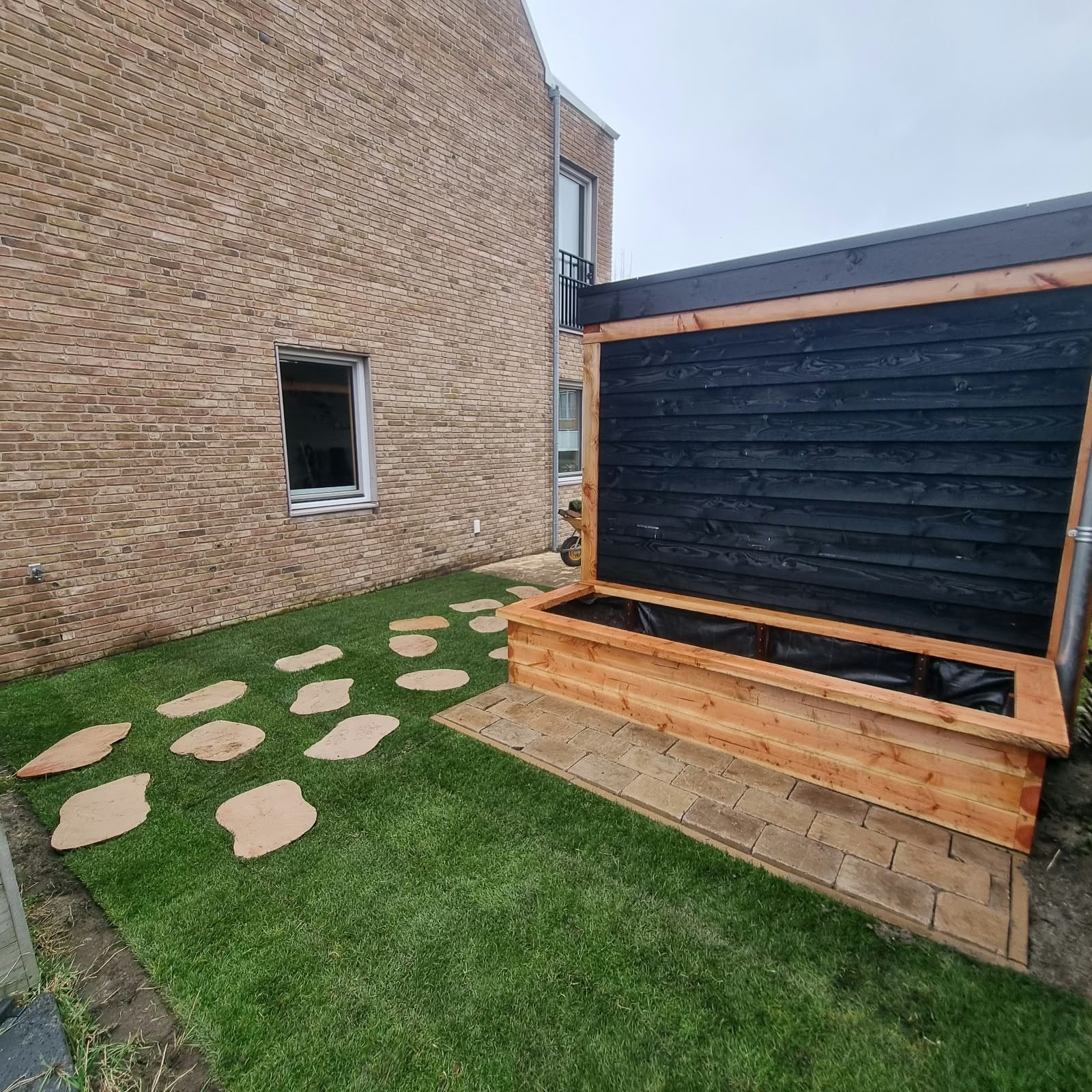 Tuin met kunstgras en stapstenen