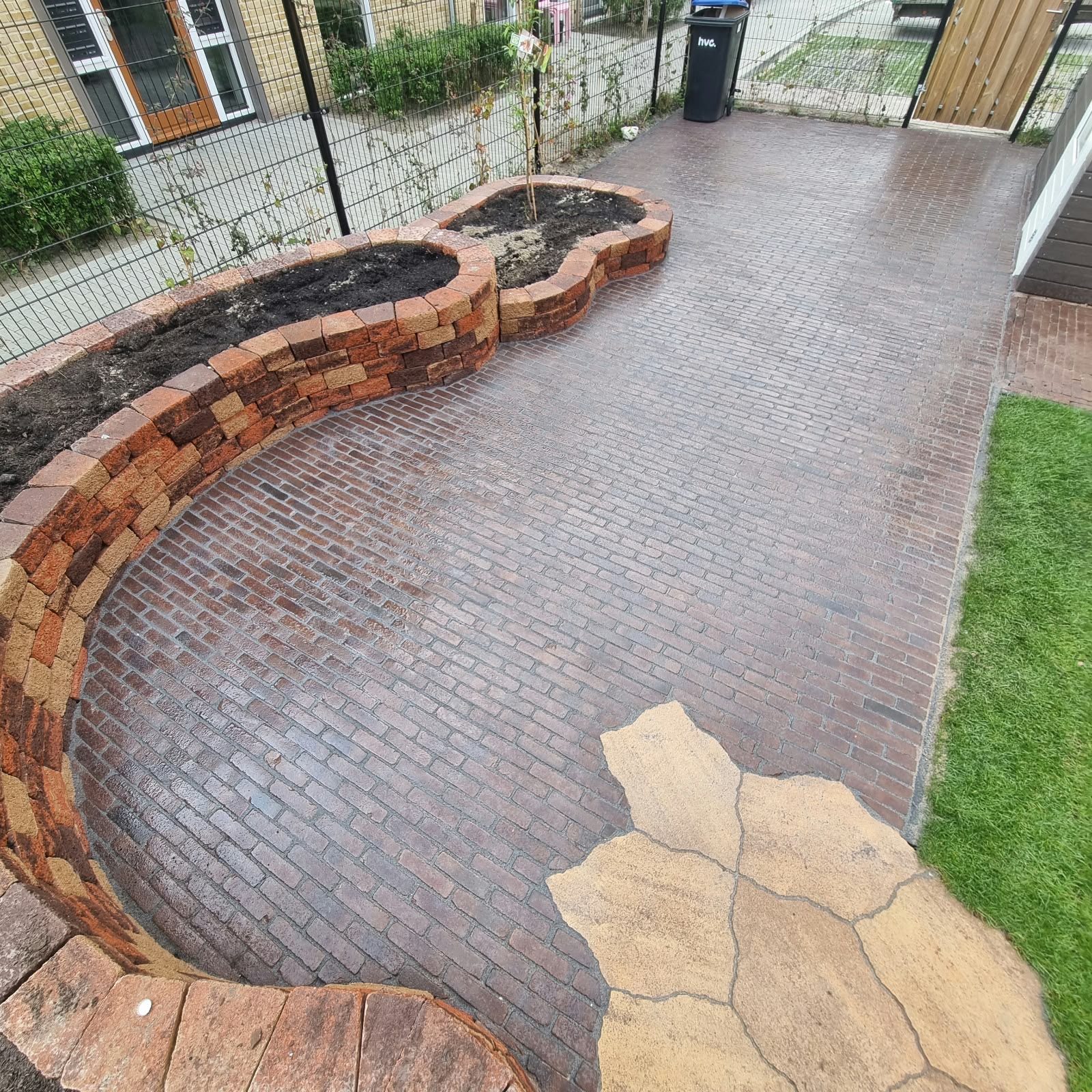 Tuinontwerp met gebogen plantenbakken van oude klinkers