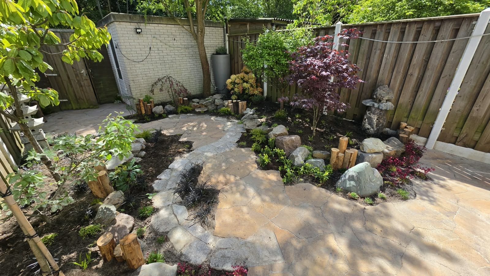 Tuinontwerp met natuurstenen pad, rotsen en borders
